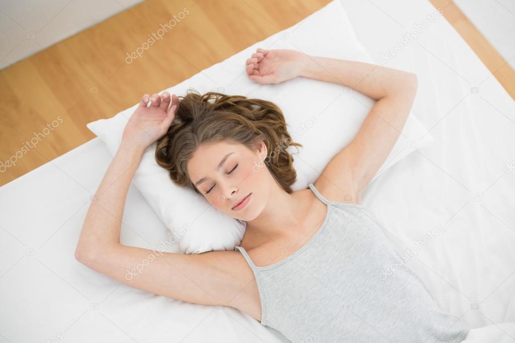 Calm woman sleeping while lying on her bed