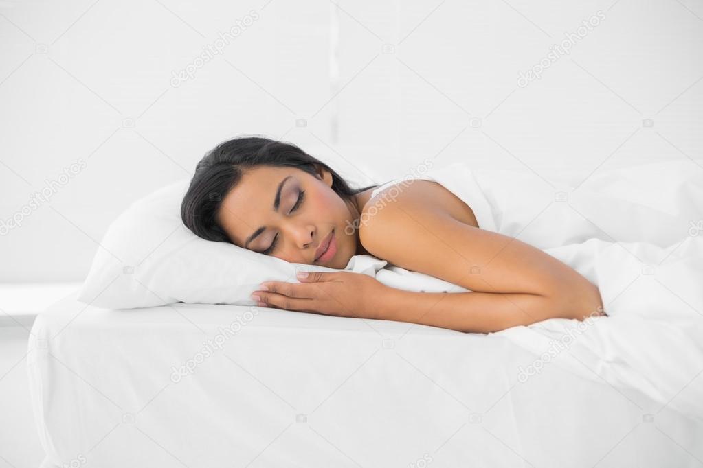 Calm sleeping woman lying on her bed