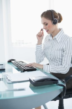 Kulaklık takmış masasında oturan kadın ajanı konsantre