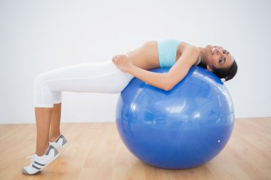 Linda mujer deportiva estiramientos en la bola de la aptitud