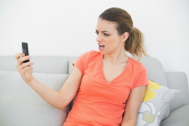 şok kadın kanepede oturan kızın smartphone bakarak