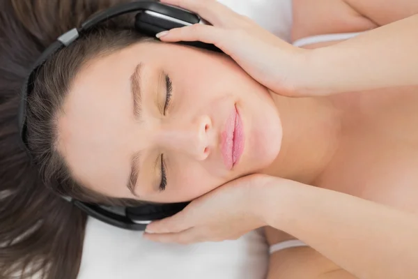 Frau genießt Musik im Bett — Stockfoto