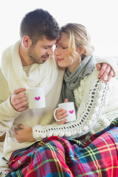 Casal amoroso em roupas de inverno com xícaras de café — Fotografia de Stock