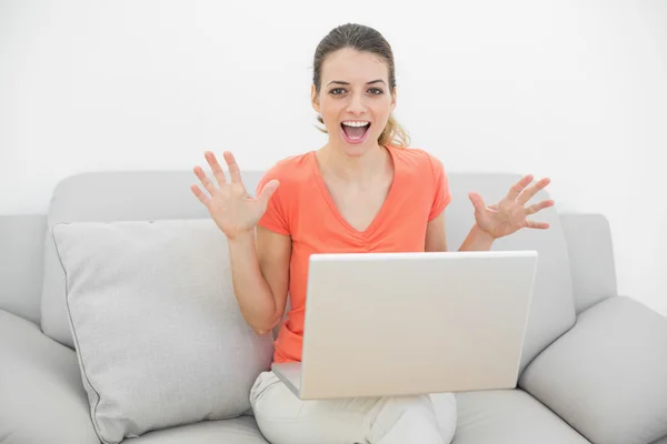 Portret van leuke juichende vrouw met behulp van haar notitieblok zittend op de Bank — Stockfoto