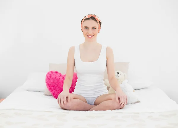 Young woman sitting on her bed — Stock Photo, Image