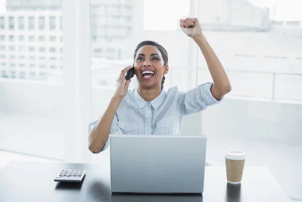 Young businesswoman sitting at her desk cheering — Stock Photo, Image