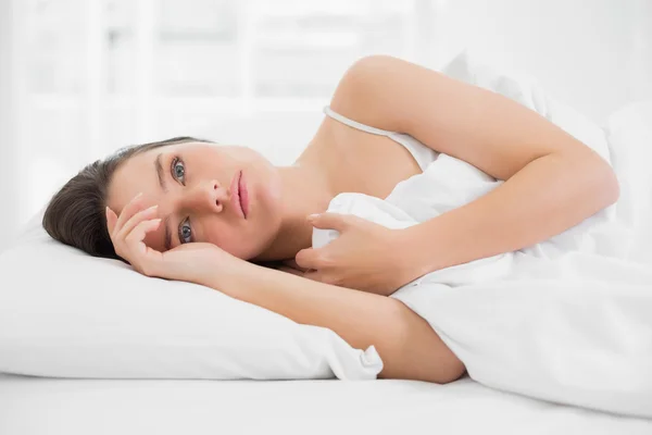 Beautiful woman looking away in bed — Stock Photo, Image