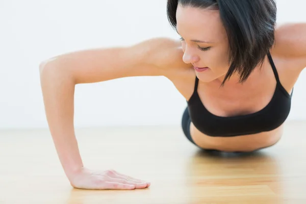 Bestämd kvinna göra push ups i fitness-studio — Stockfoto