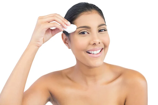 Smiling nude brunette holding cotton ball looking at camera — Stock Photo, Image