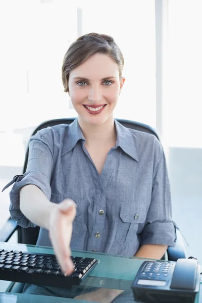 Amistosa mujer de negocios acogedora mientras está sentada en su escritorio —  Fotos de Stock