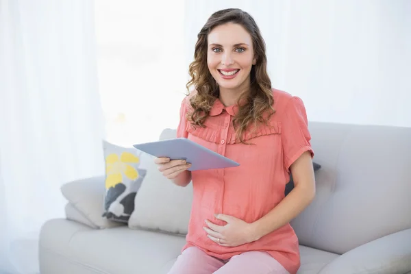 Mulher grávida alegre segurando seu tablet — Fotografia de Stock