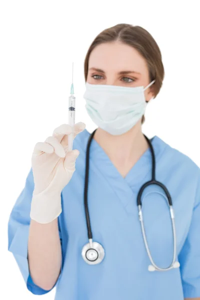 Pretty young woman doctor holding an injection — Stock Photo, Image