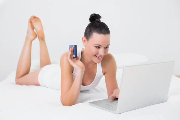 Mujer casual haciendo compras en línea en la cama —  Fotos de Stock