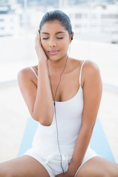 Calm toned brunette listening to music — Stock Photo, Image