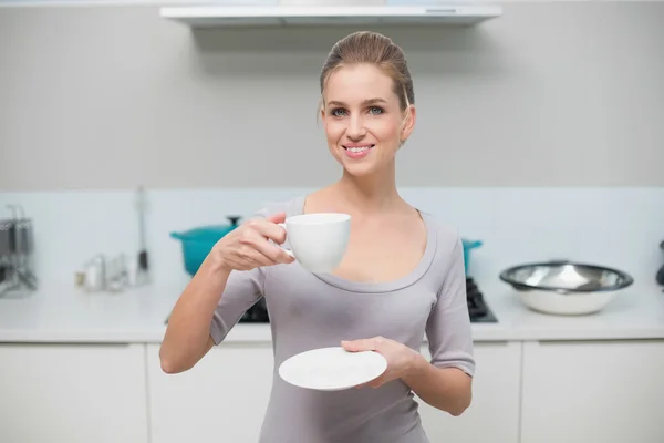 Alegre hermosa modelo mirando cámara celebración taza — Foto de Stock