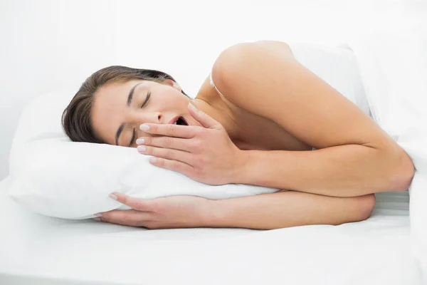 Mujer joven bostezando en la cama —  Fotos de Stock