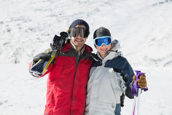 Porträt eines glücklichen Paares mit Skibrettern im Schnee — Stockfoto
