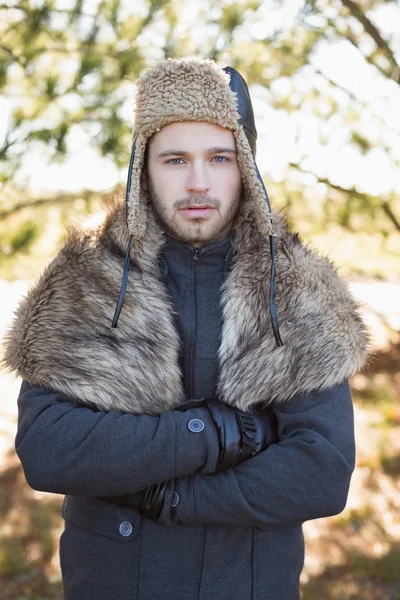 Schöner Mann in warmer Kleidung steht im Wald — Stockfoto