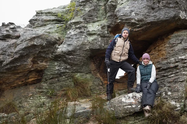 ハイキングに岩の上の若いカップルの笑みを浮かべてください。 — ストック写真