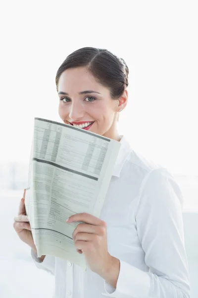 Улыбающаяся деловая женщина держит газету — стоковое фото