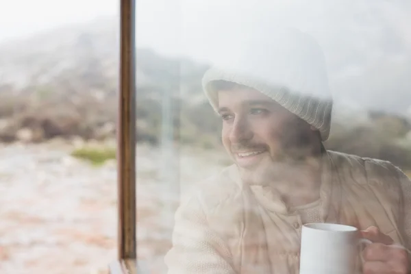 Thoughtful man with cup looking out through window — Stock Photo, Image