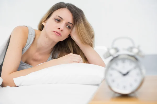 Müde junge Frau liegt unter der Decke auf ihrem Bett — Stockfoto