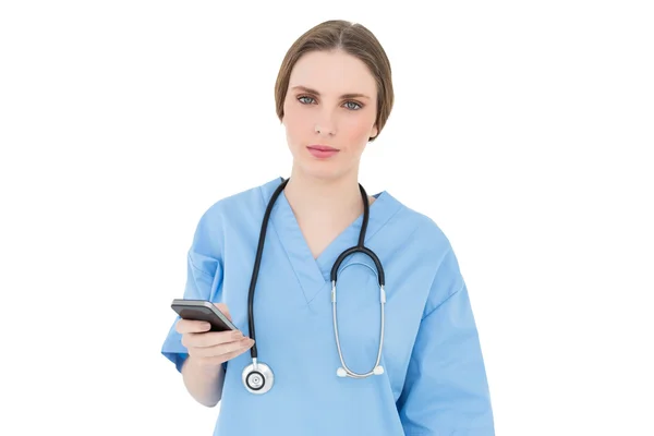 Młoda kobieta lekarz trzymając jej smartphone — Zdjęcie stockowe