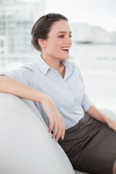 Vista lateral de uma mulher alegre bem vestida no sofá — Fotografia de Stock