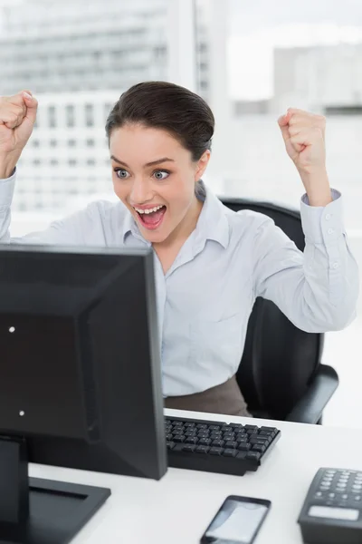 Excited businesswoman looks at the computer screen in office — Stock Photo, Image