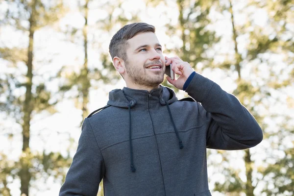 Smiling man using mobile phone outdoors — Stock Photo, Image