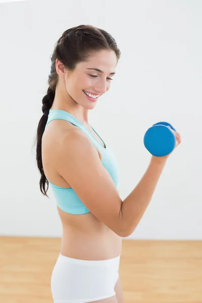 Mulher sorridente com haltere no estúdio de fitness — Fotografia de Stock
