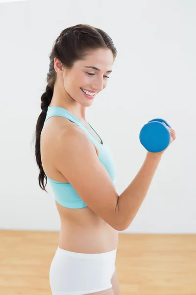 Donna sorridente con manubrio in palestra — Foto Stock