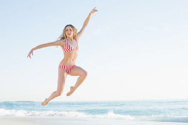 Attraktive blonde Frau springt am Strand — Stockfoto