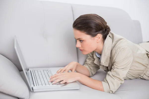 Mulher bonita usando laptop no sofá em casa — Fotografia de Stock