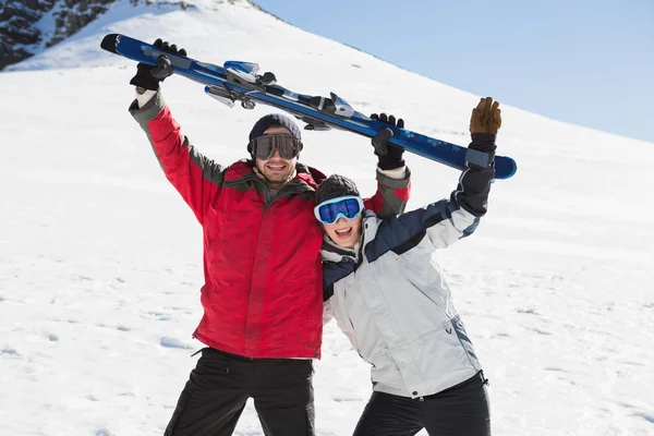 Wesoły para trzyma się Zarząd ski na śniegu — Zdjęcie stockowe