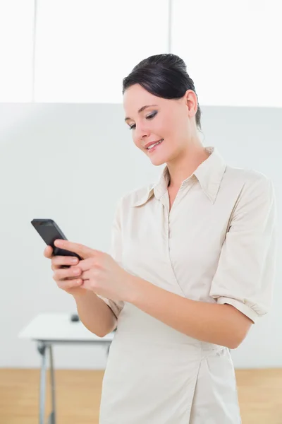 Бизнесмен смотрит на мобильный телефон в офисе — стоковое фото