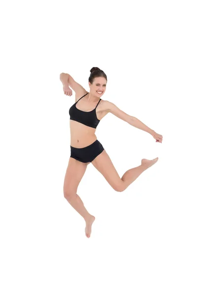 Спортивная молодая женщина, прыгающая на белом фоне — стоковое фото