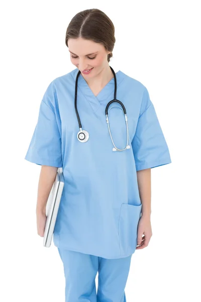 Young female doctor holding a white notebook and looking down — Stock Photo, Image