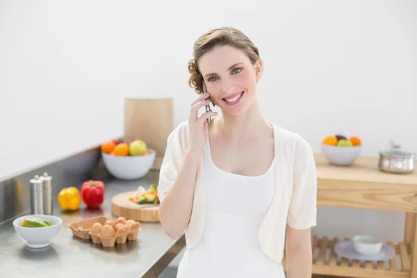 Content young woman honing while standing in kitchen — Stock Photo, Image
