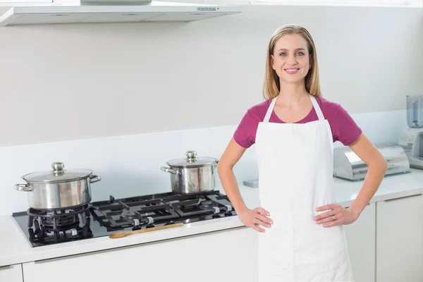 Casual smiling blonde standing next to stove — Stock Photo, Image