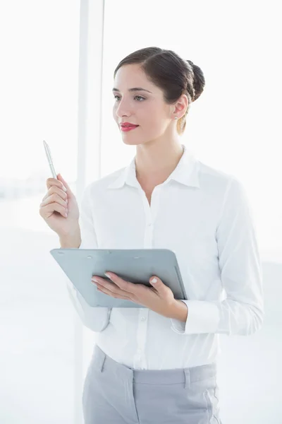 Junge Geschäftsfrau mit Klemmbrett und Stift — Stockfoto