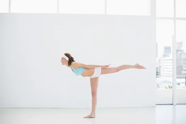 Mujer esbelta deportiva haciendo ejercicios de yoga en un pabellón deportivo — Foto de Stock