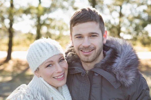 Pareja sonriente en ropa de invierno en el bosque — Foto de Stock