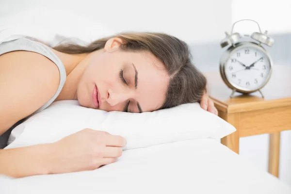 Ελκυστική ήρεμη γυναίκα ξαπλωμένη στο κρεβάτι της, κάτω από την κάλυψη στον ύπνο — Φωτογραφία Αρχείου