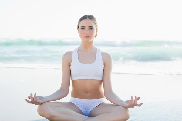 Prachtige jonge vrouw mediteren zittend op het strand — Stockfoto
