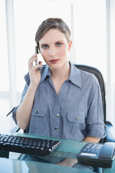Poważne kobiece kobieta siedzi przy biurku a dzwoniąc — Zdjęcie stockowe