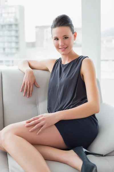 Mooie goed geklede jonge vrouw zittend op de Bank — Stockfoto