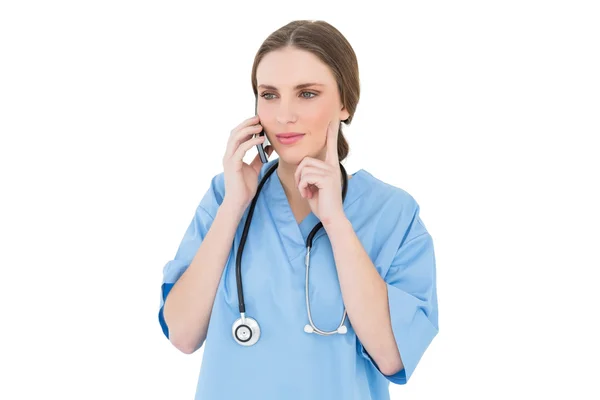 Thinking woman doctor phoning with her smartphone — Stock Photo, Image