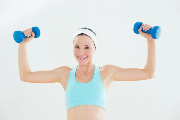 Fit smiling woman exercising with dumbbells — Stock Photo, Image