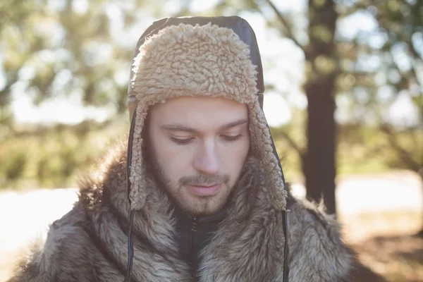 Nahaufnahme eines Mannes in warmer Kleidung, der in den Wald schaut — Stockfoto